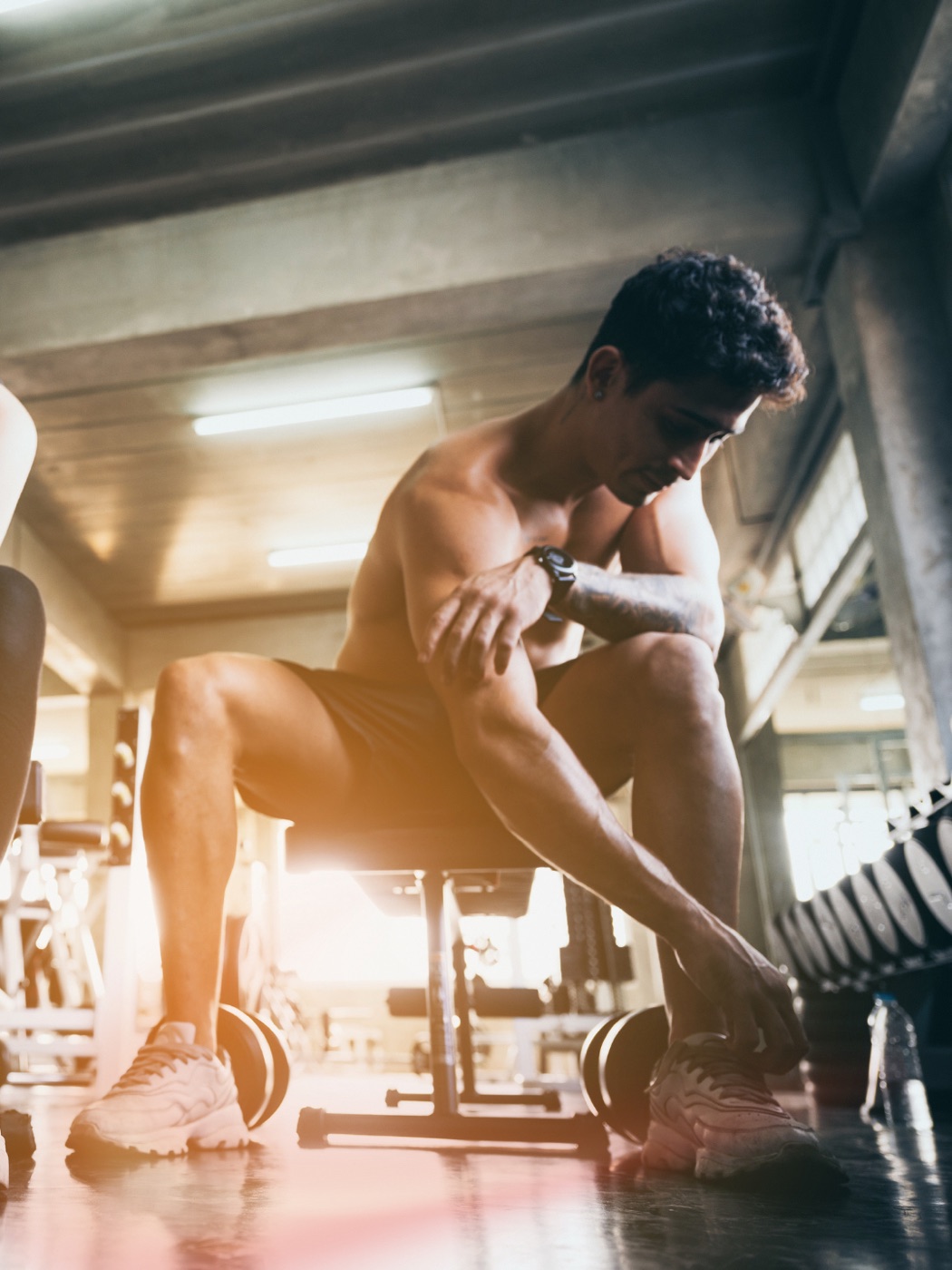 A man resting between sets in a gym